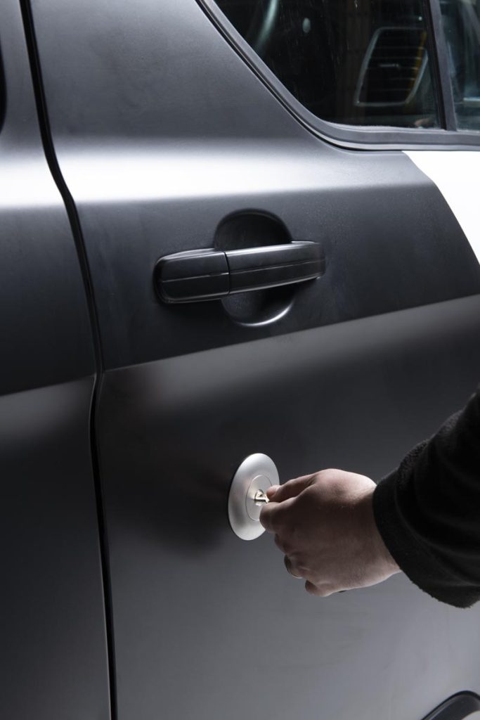 key being turned by hand on the drivers door of a van unlocking a ford replacement lock
