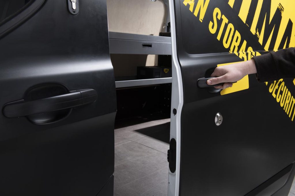 hand opening the sliding door of a van showing the van guard slam lock 